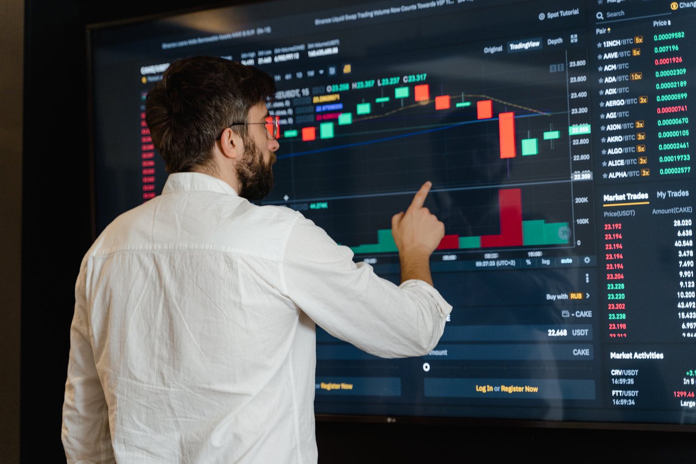 Man in White Dress Shirt Analyzing Data Displayed on Screen, Best Laptop for Trading in 2024: For Day Traders and Investors, Best Laptop for Trading in 2024: For Day Traders and Investors